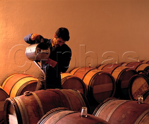 Toppingup barrels after racking in the   1styear chai at Chteau MoutonRothschild   Pauillac Gironde France  HautMdoc  Bordeaux
