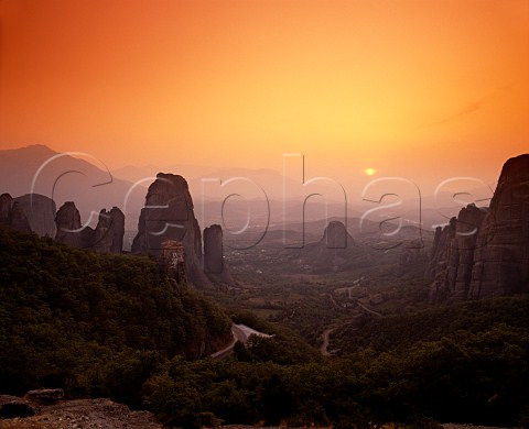 Sunset over Roussano Monastery amidst the rock   pinnacles of the Meteora  the Plain of Thessaly   lies beyond    Greece