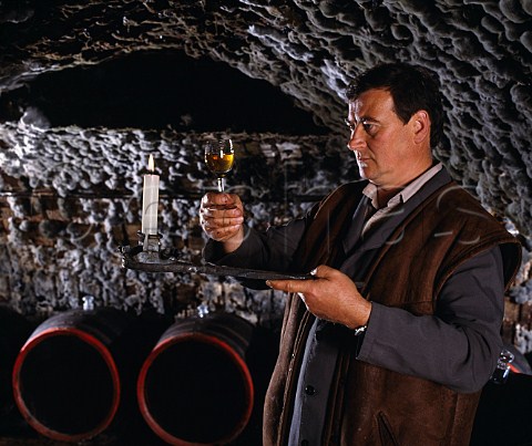Gyula Borsos checks the clarity of wine taken from   barrel in the ancient mouldcovered cellars of Tokaj   Kereskedhz Tolcsva Hungary  Tokaji