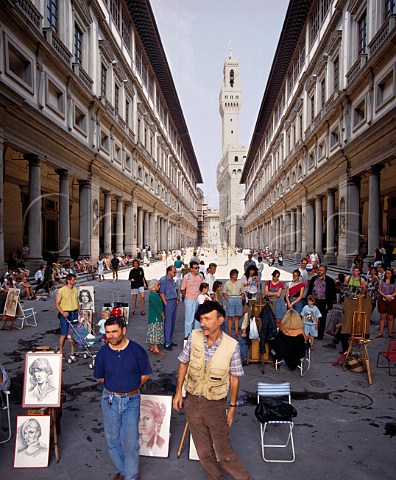 Artists in the Piazzale degli Uffizi with the Palazzo Vecchio in distance Florence Tuscany Italy