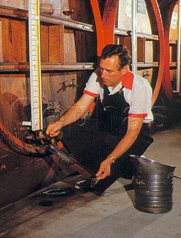 Maitre des Chais Michel Poulain removing a sample of   20 year old vintage calvados from the final blending   barrel at the chais of the Pere Magloire company   Pont LEveque Normandy