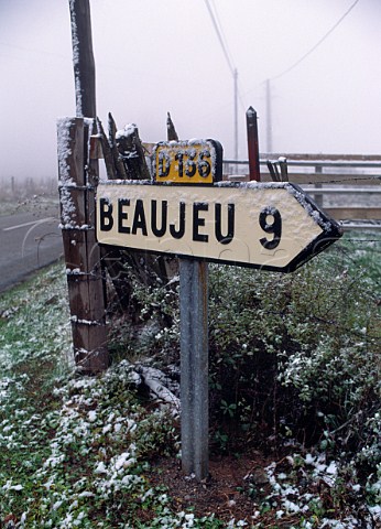 Snow on road sign pointing to Beaujeu in the Beaujolais wine region France