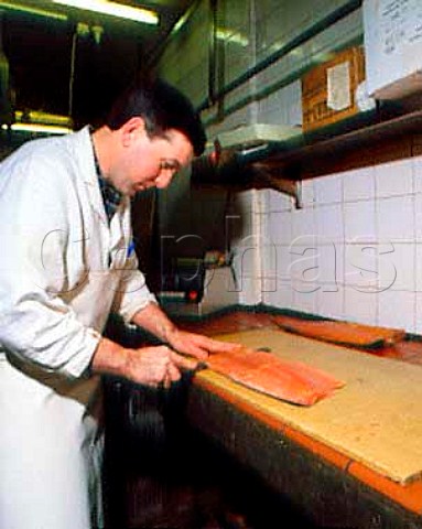 Hand slicing of sides of smoked salmon at AHJarvis  and Sons Kingston upon Thames Surrey