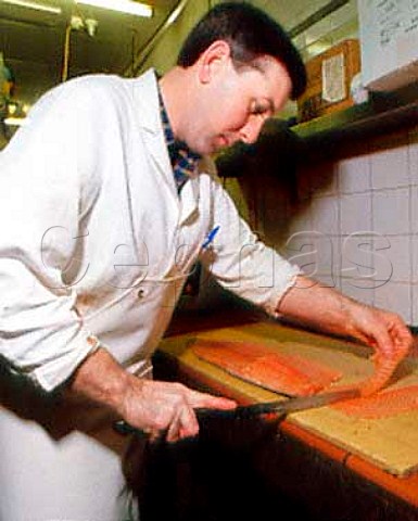 Handslicing of sides of smoked salmon at AHJarvis  and Sons Kingston upon Thames Surrey England