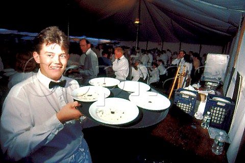 Waiter carrying tray of plates at the Napa Valley Wine Auction  Meadowood Resort St Helena Napa Valley California