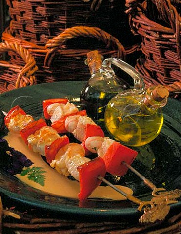 Fish and seafood kebabs with dual carafe containing  virgin olive oil and extra virgin olive oil