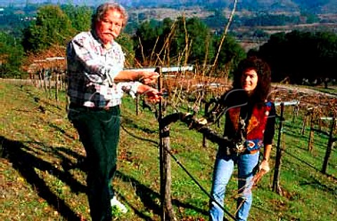 Duane Cronin pruning vines  his wife   Nancy collects the prunings for   wreathmaking  San Mateo Co California  Santa Cruz Mountains AVA