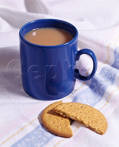 Mug of tea with milk and a digestive biscuit