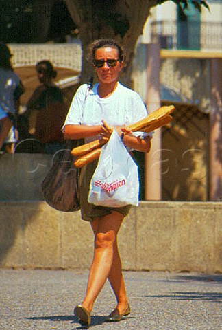Woman carrying a baguette in Cannes   AlpsMaritime France   ProvenceAlpesCte dAzur