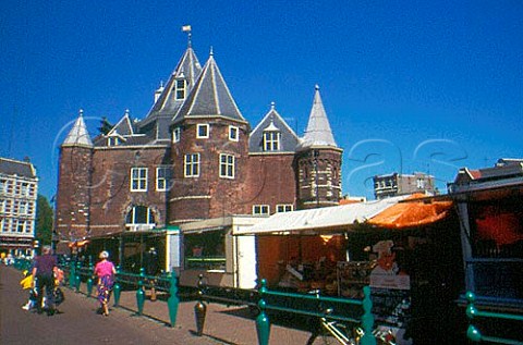 Cheese and other stalls on the Nieuw   Markt with Waagebouw Weighhouse   beyond Amsterdam Netherlands