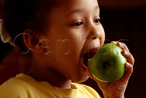 Young girl eating an apple