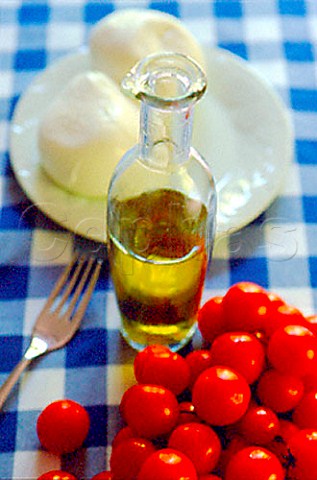 Bottle of olive oil cherry tomatoes and  mozarella cheese