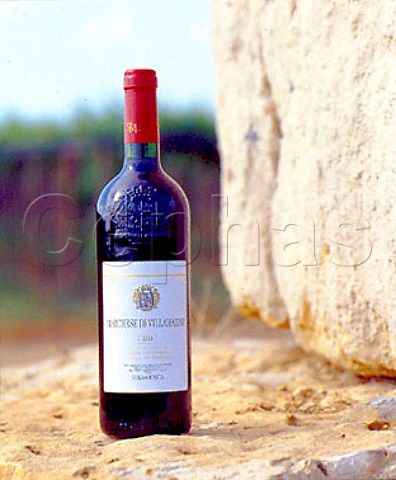 Bottle of Marchese di Villamarina wine standing on   rocks that were excavated prior to the vineyard   planting   Sella  Mosca Alghero Sardinia Italy
