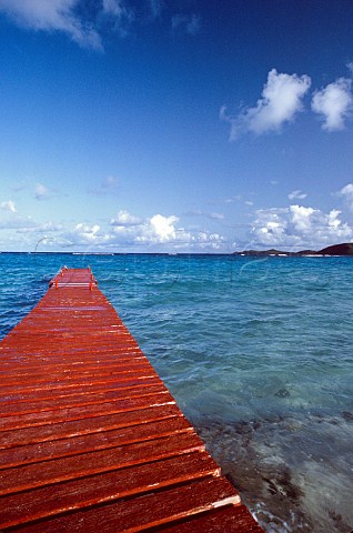 Red wooden jetty juts out to an azure Caribbean sea