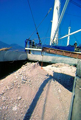 Loading Bentonite onto a ship Quarried   from the island it is used amongst   other things as a fining agent in   winemaking  Milos Cyclades islands Greece