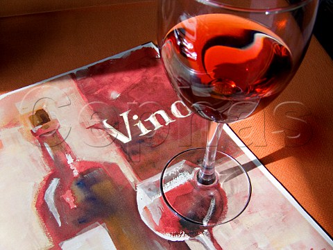 Glass of red wine on a sunny restaurant table with wine list Spain