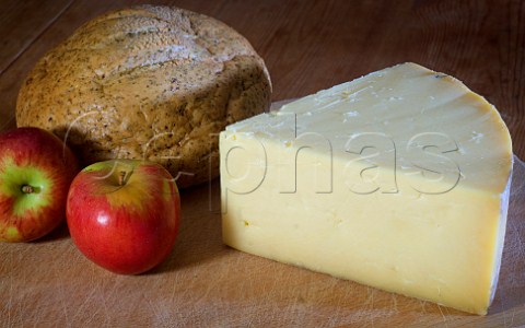 Piece of Traditional Farmhouse Cheddar cheese with   bread and apples Westcombe Dairy Evercreech   Somerset England