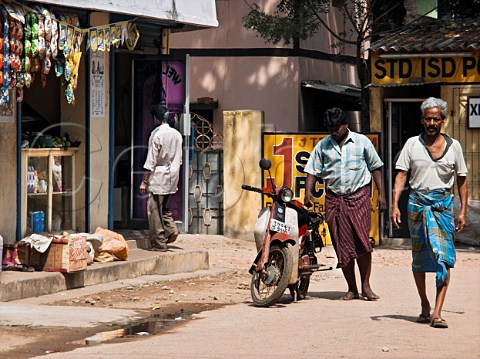 Indian men walking along road Chennai Madras   India