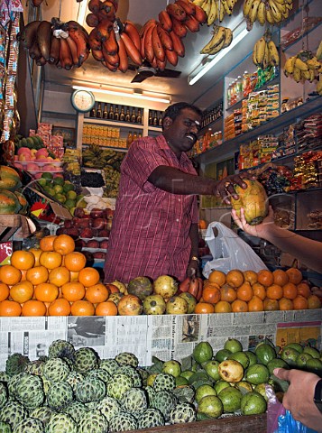 Indian man selling fruit in general store Chennai  Madras India