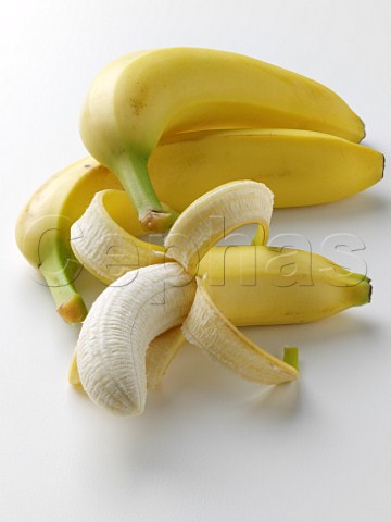 Half peeled banana and bananas