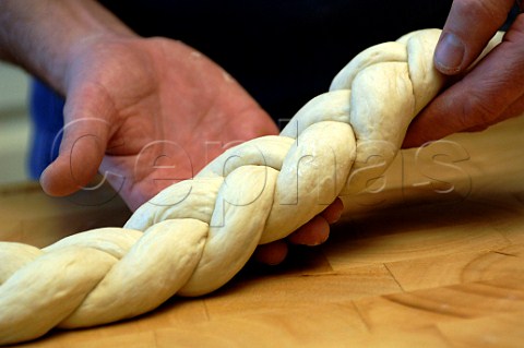 Baker holding a bread plait ready for baking