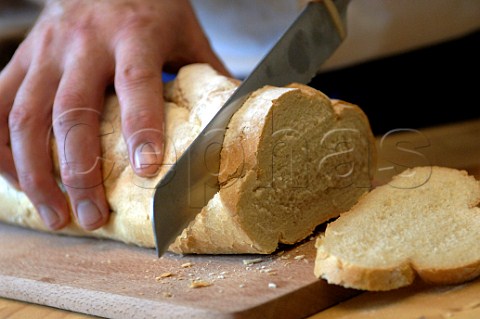 Slicing loaf of bread on a board