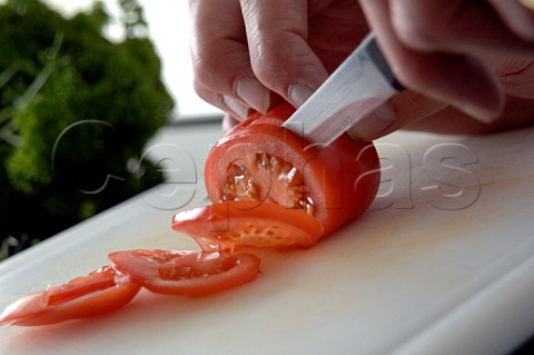 Slicing tomato with a kitchen knife