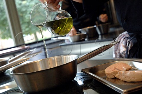 Pouring olive oil into pan to cook veal