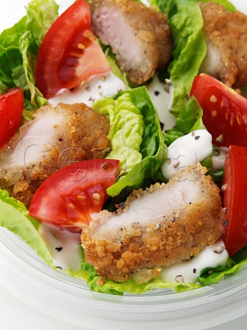 Breadcrumbed fish in caesar salad