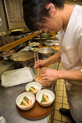Preparing minced chicken and sticky rice wrapped in a sakura cherry leaf in a Japanese restaurant kitchen