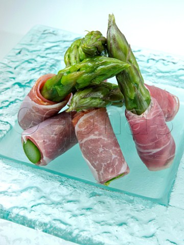 Plate of asparagus spears wrapped in parma ham