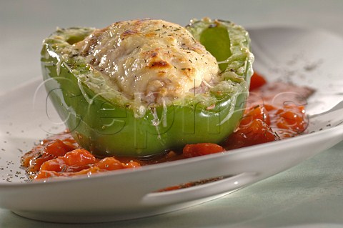 Green pepper stuffed with cheese topped sausage meat on a bed of chopped tomatoes