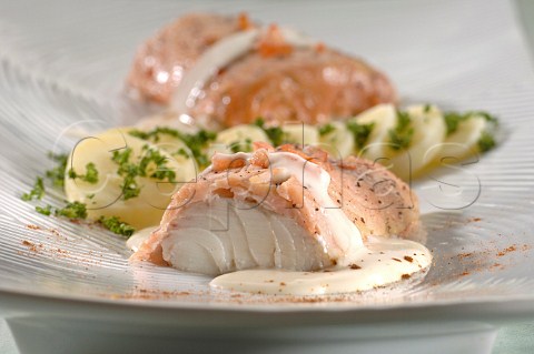 Cod covered in salmon with slices of boiled potato sprinkled with herbs