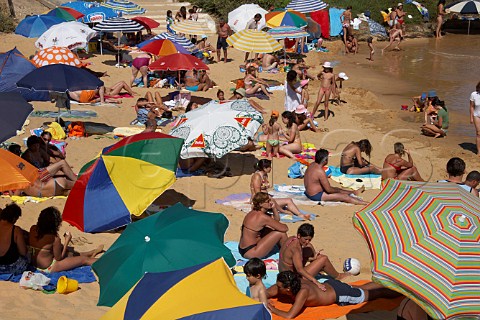 People sunbathing on the beach by the Mira River estuary at Vila Nova de Milfontes Odemira Portugal