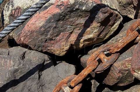 Mooring rope and rusty chain on harbour rocks Vila Nova de Milfontes Odemira Portugal