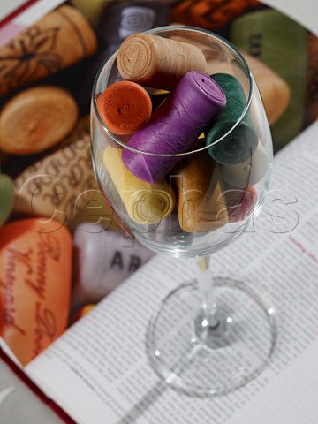 Wine glass full of plastic corks standing on wine book