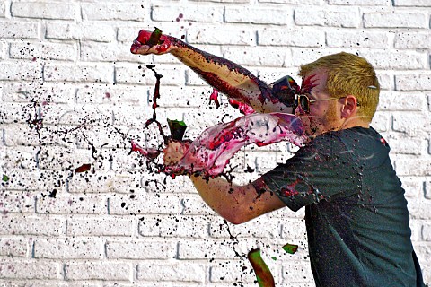 Winemaker Grant Phelps smashing bottle of red wine  Chile