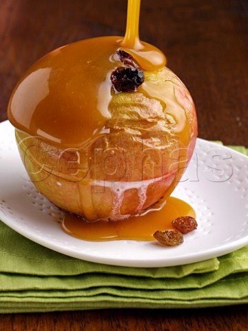 Butterscotch sauce pouring onto a baked apple