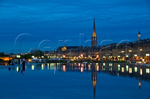 Pont de Pierre and the spire of the church of StMichel reflecting in the fountain lake at Place de la Bourse Bordeaux Gironde France