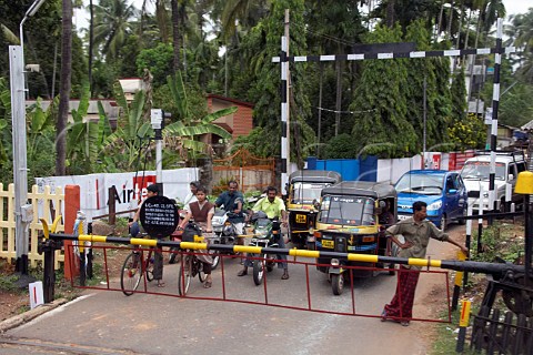 Vehicles waiting at a level crossing near a train station between Kochi Cochin and Kannur Cannanore Kerala India