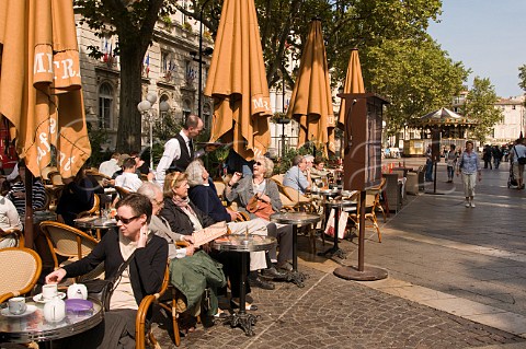 People relaxing in one of the street cafs in Place de LHorloge Avignon Vaucluse Provence France