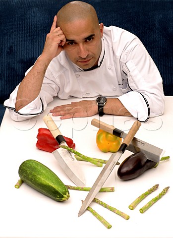 Thomas Olivera head chef at The RitzCarlton sitting at a table with Bunmei knives and various vegetables Santiago Chile