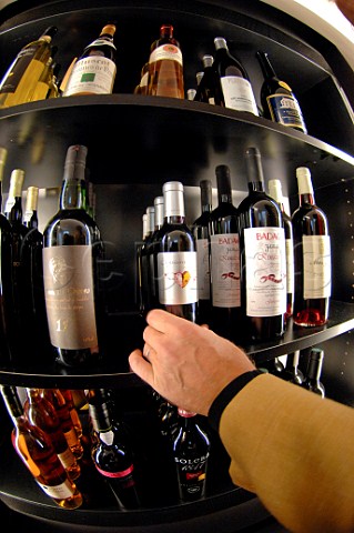 Selecting a bottle of wine from a shelf