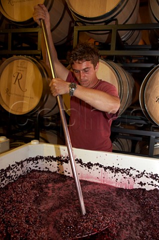 Hand plunging a tank of fermenting Merlot in winery of Rappahannock Cellars  Huntly Virginia USA