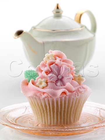 Pink iced cupcake and green teapot
