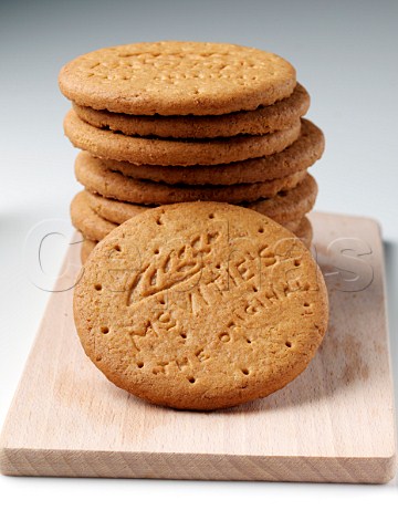 A stack of digestive biscuits on a wooden board