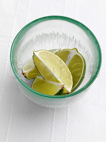 Cut limes in a green glass bowl