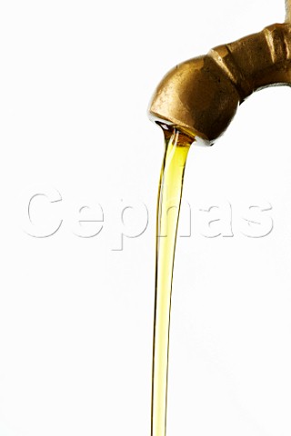Olive oil flowing from a brass tap