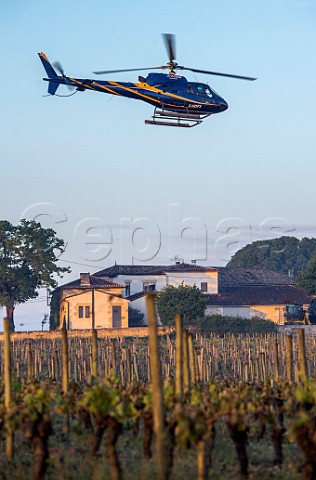 Helicopter being used to circulate warmer air and prevent frost damage to vineyard in subzero spring temperatures of April 2017  Chteau Figeac Stmilion Gironde France  Saintmilion  Bordeaux