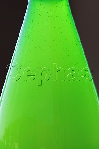 Backlit green wine bottle containing Federweisser with the rising carbon dioxide bubbles from the ongoing fermentation of the wine